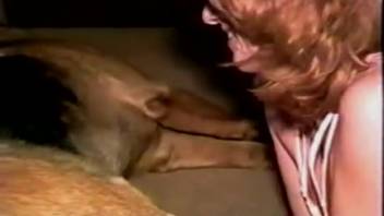 Young redhead teen stuffs lengths of appealing dog penis into both her orifices