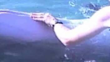 Man stimulates hole of sea animal outdoor with his hand