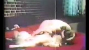 Voluptuous dark-haired woman receives tongue action from a canine in vintage animal-themed clip