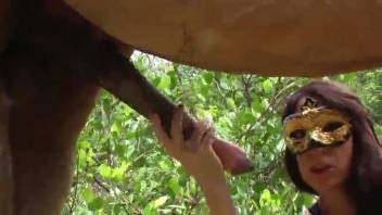 Disguised bestiality lover orally stimulating a creature's erect penis