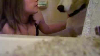 Sexy cutie is kissing her white dog with passion