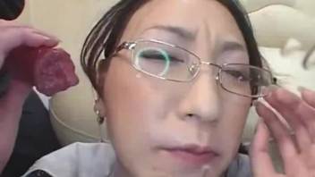 Dressed Asian lady relishes cum on her face after blowing canine cock