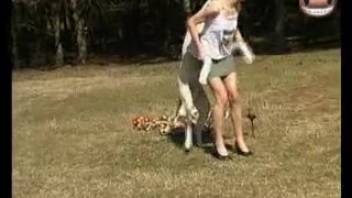 Sexy woman gets naughty with the dog in an outdoor zoo scene